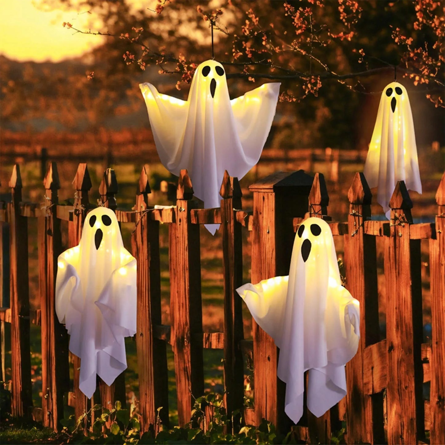Group of glowing ghosts on a front yard at night.