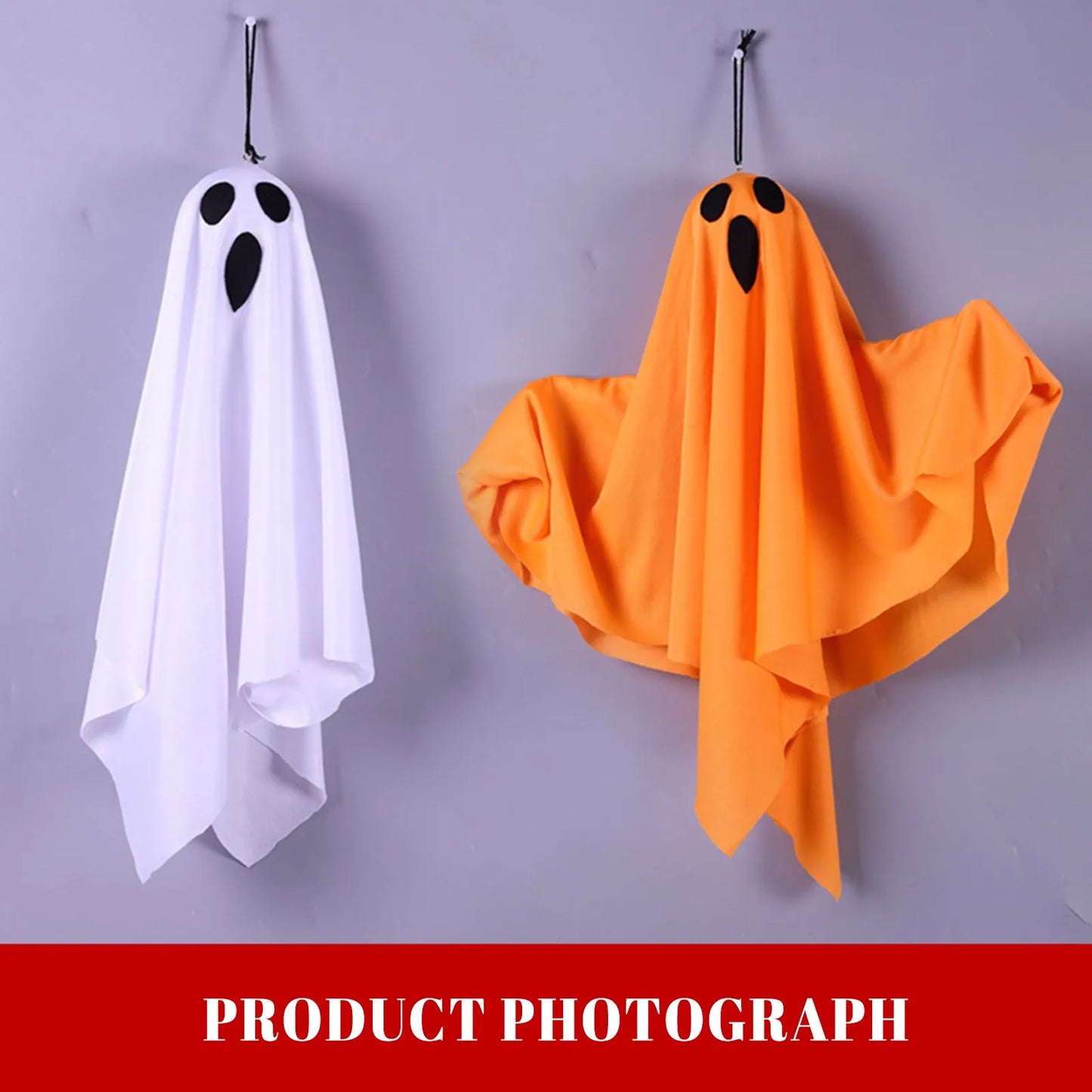 White and orange ghost props hanging on a clothes rack.