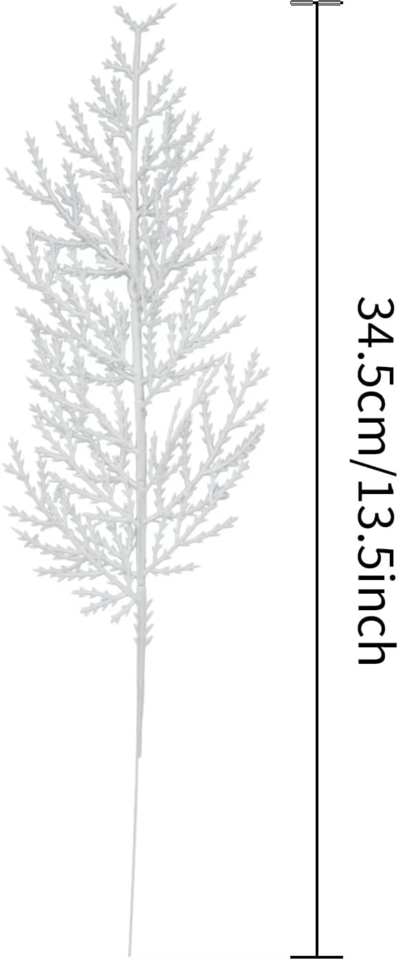 Hand holding a white artificial pine spray with falling snow backdrop