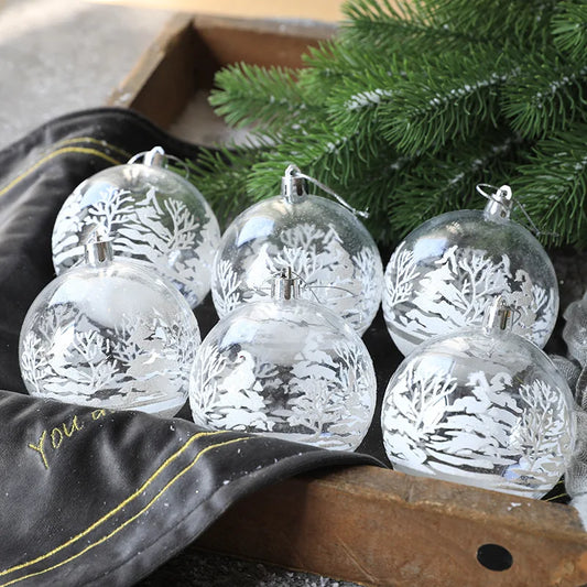 Large hero of clear etched winter-scene baubles under a pine branch.