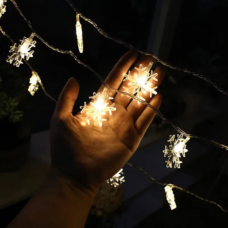 Hand holding warm white snowflake LED string lights showing detail of the cover