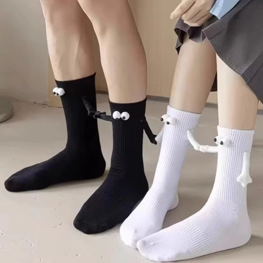 Black and white mid-tube magnetic socks with 3D eyes worn on feet