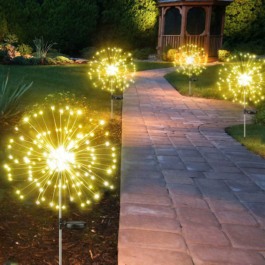 Solar LED firework fairy lights glowing along a garden pathway at night