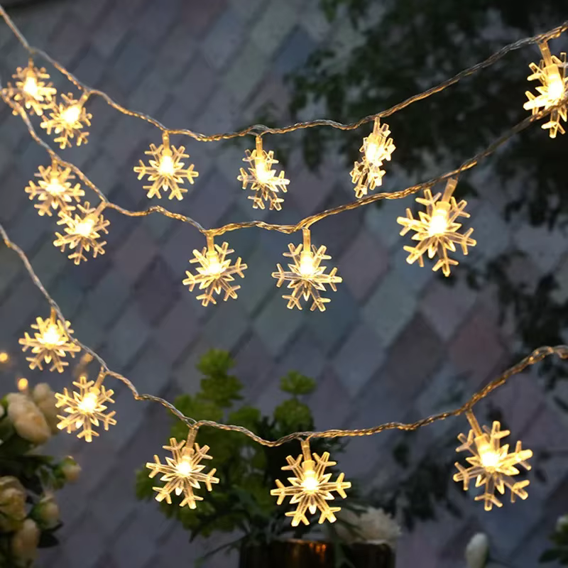 Warm white snowflake string lights draped across a wall for seasonal decoration